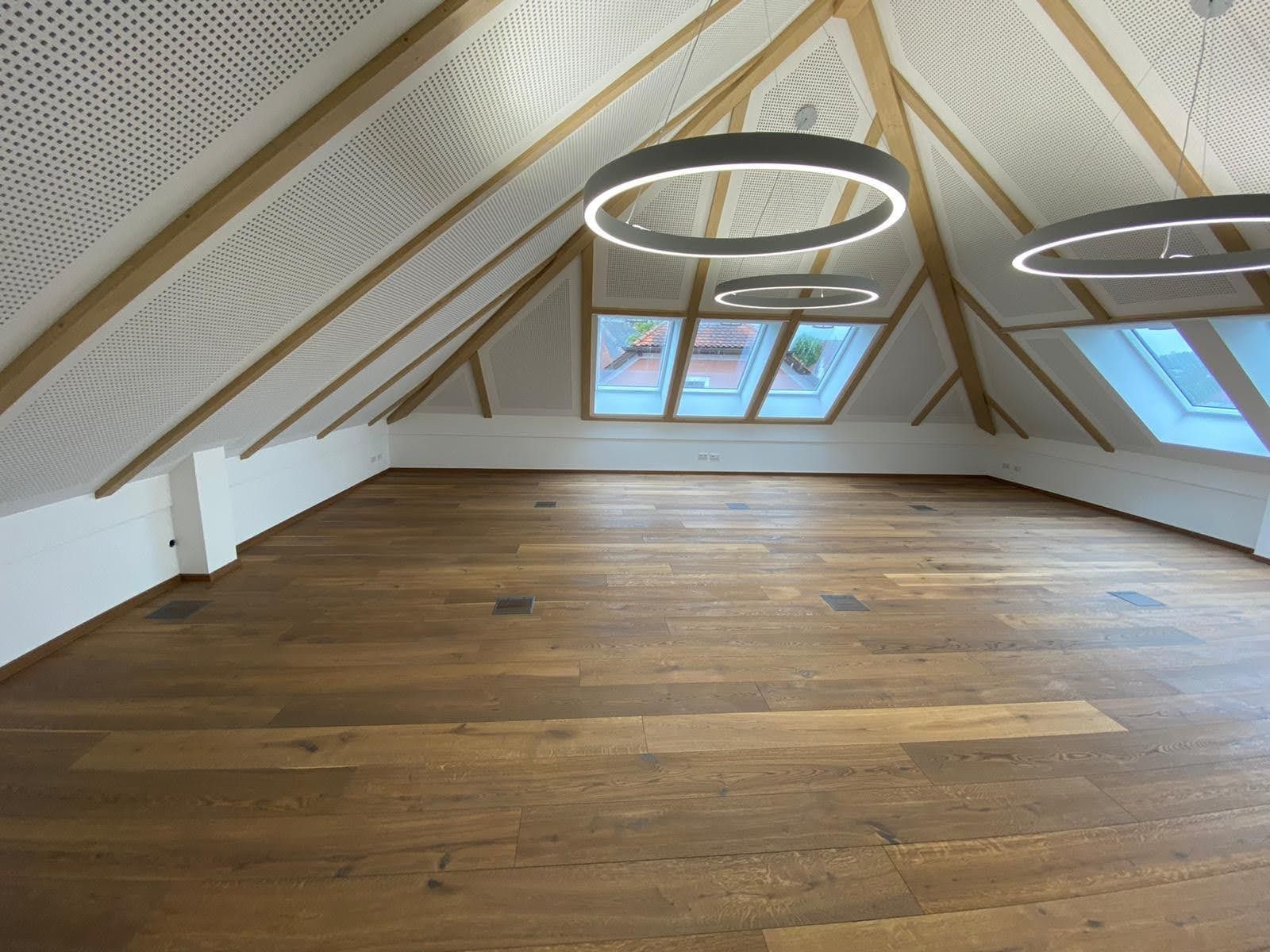 Ein leerer Raum mit Holzboden und weißen Wänden