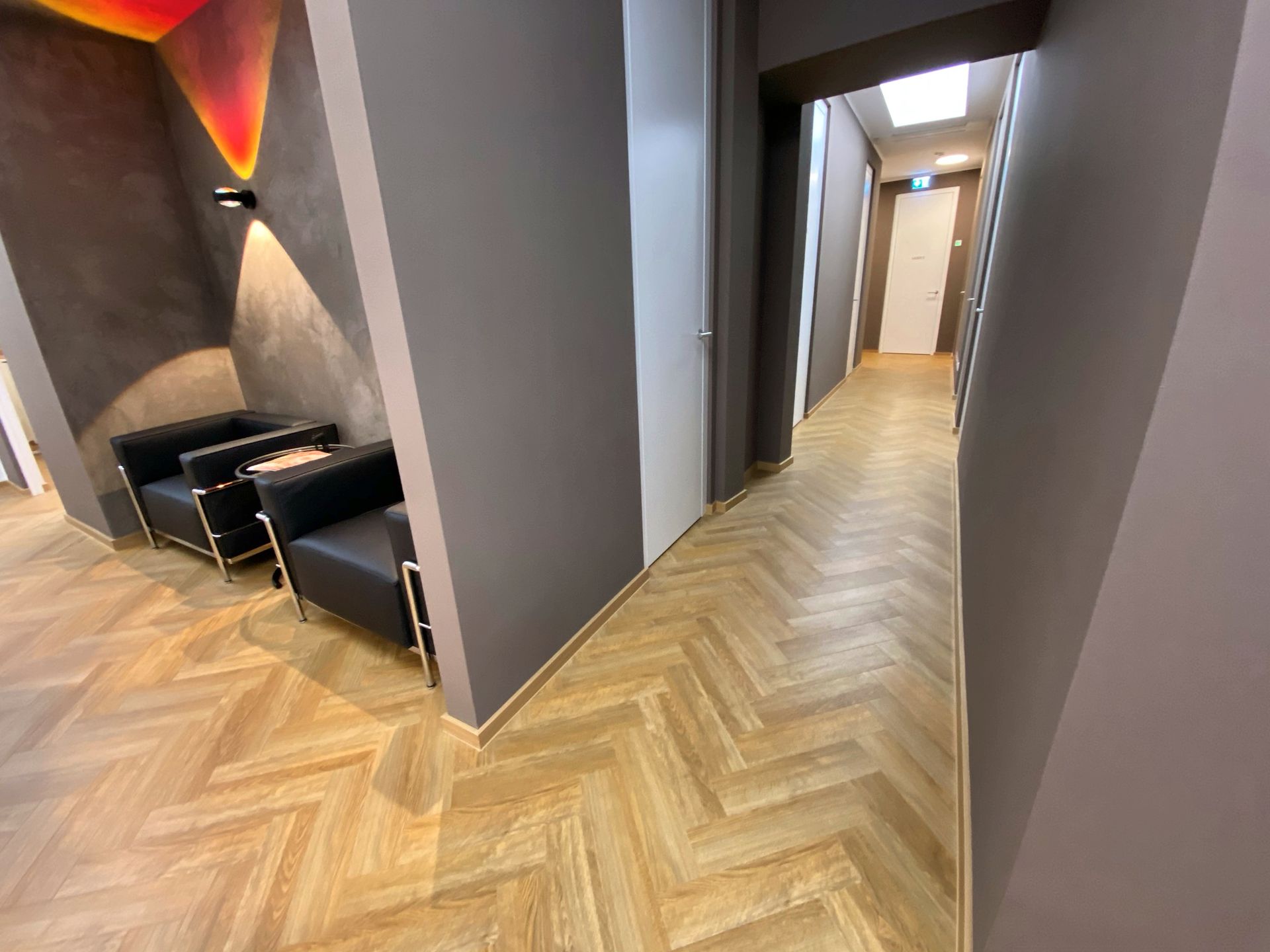 Ein Flur mit zwei Stühlen und einer Tür in der Mitte