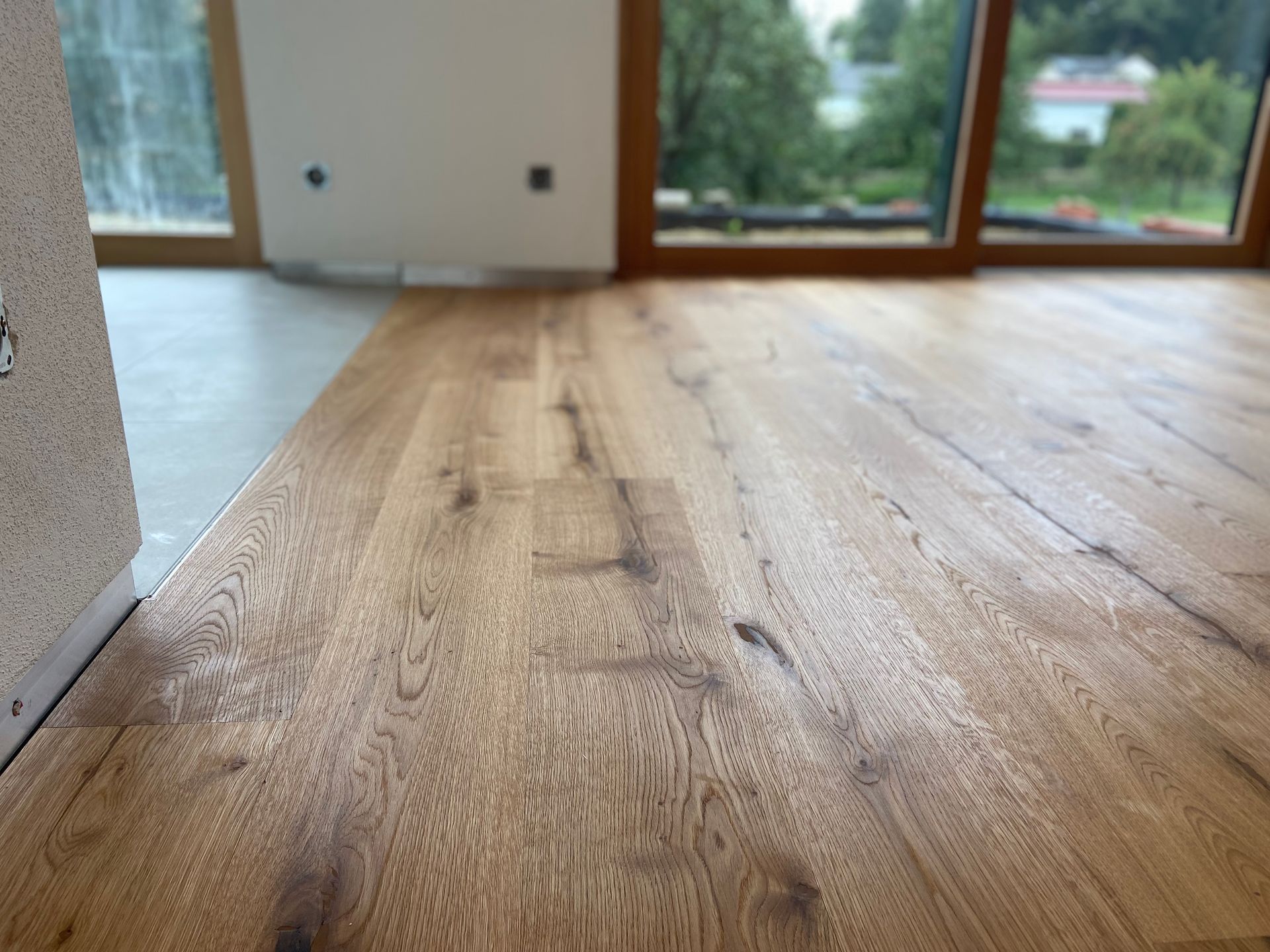 Ein Holzboden in einem Raum mit großen Fenstern