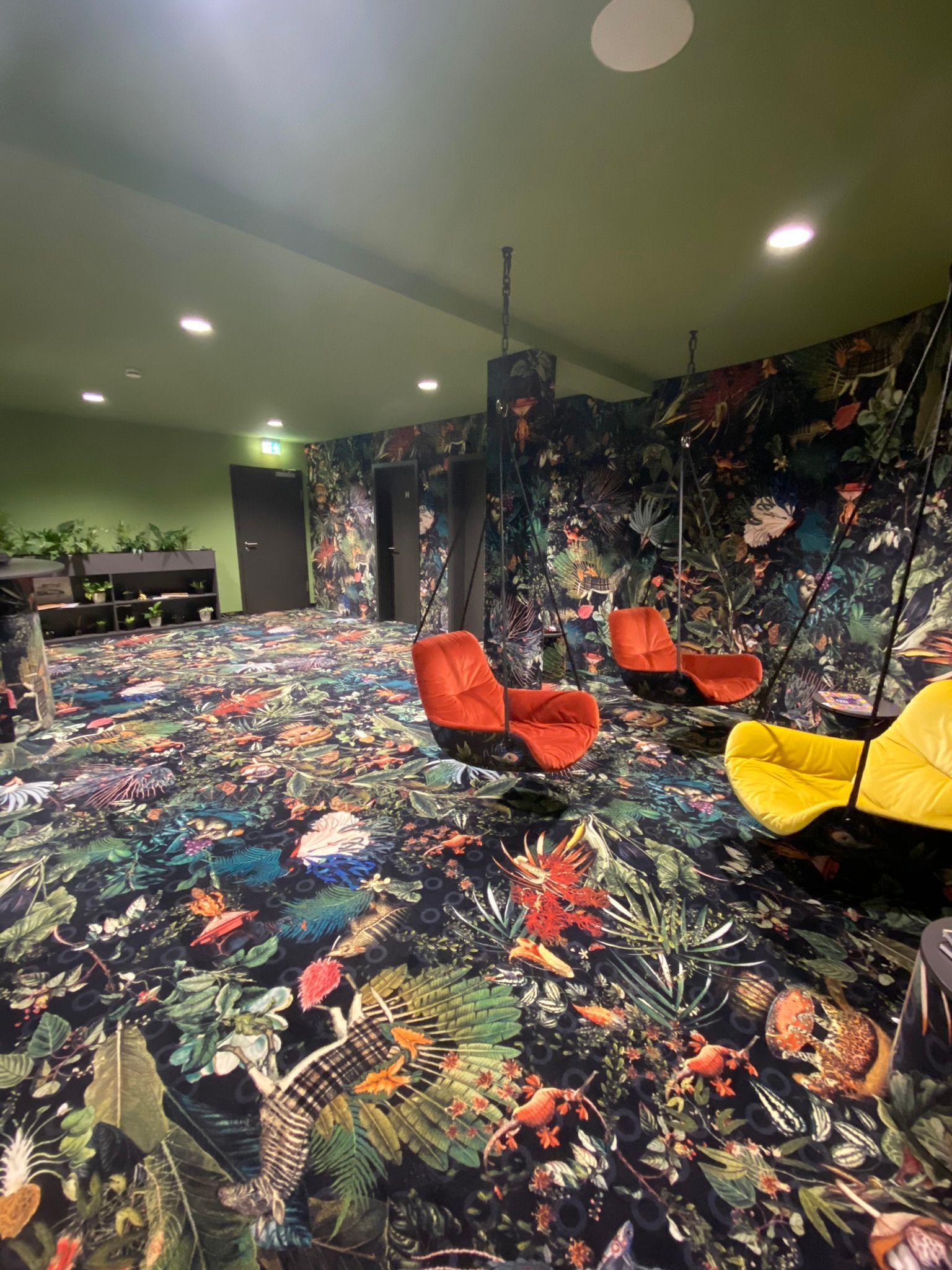 Ein Raum mit Stühlen und einem Wandbild