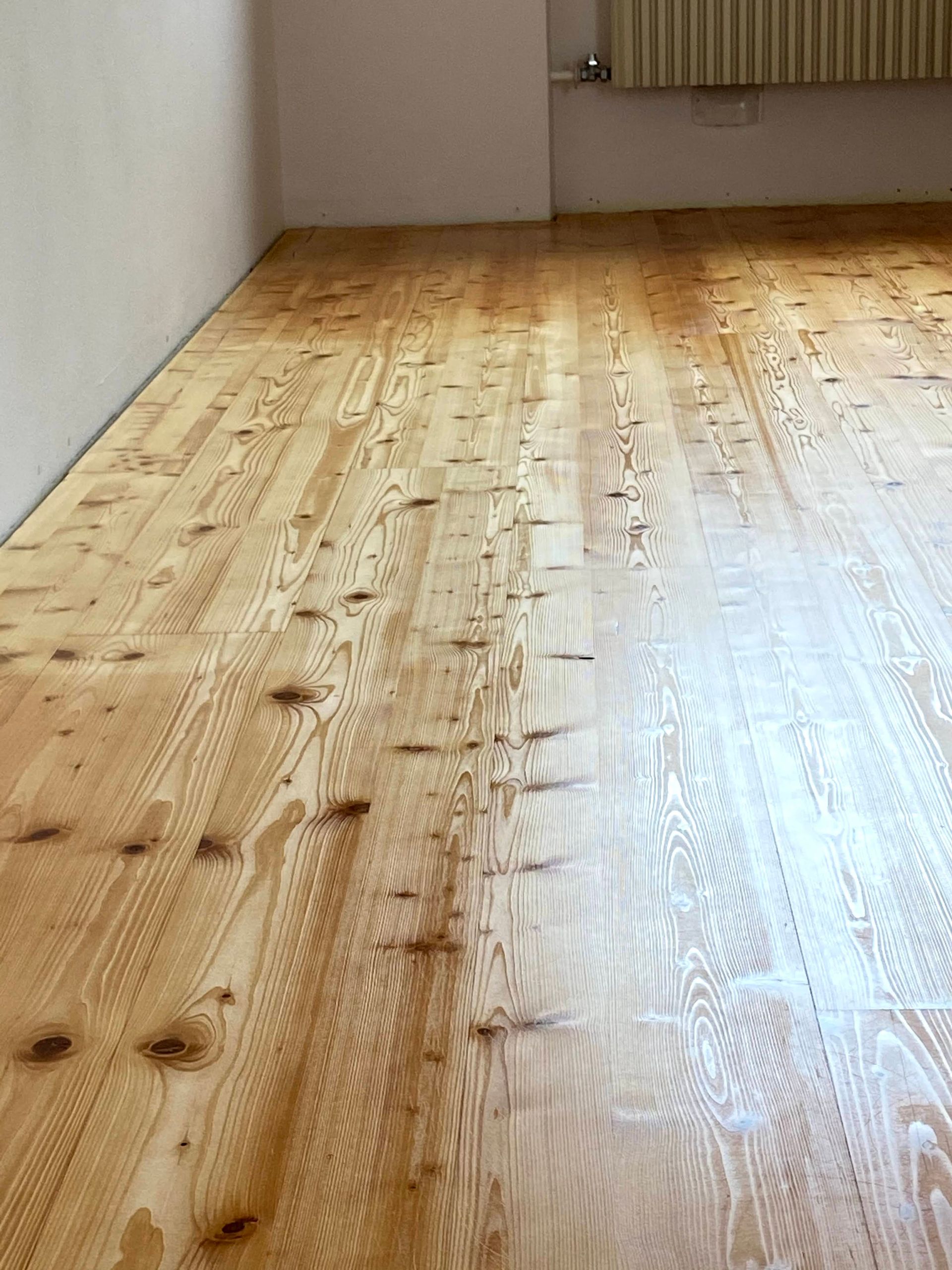 Ein Holzboden in einem Raum mit weißen Wänden