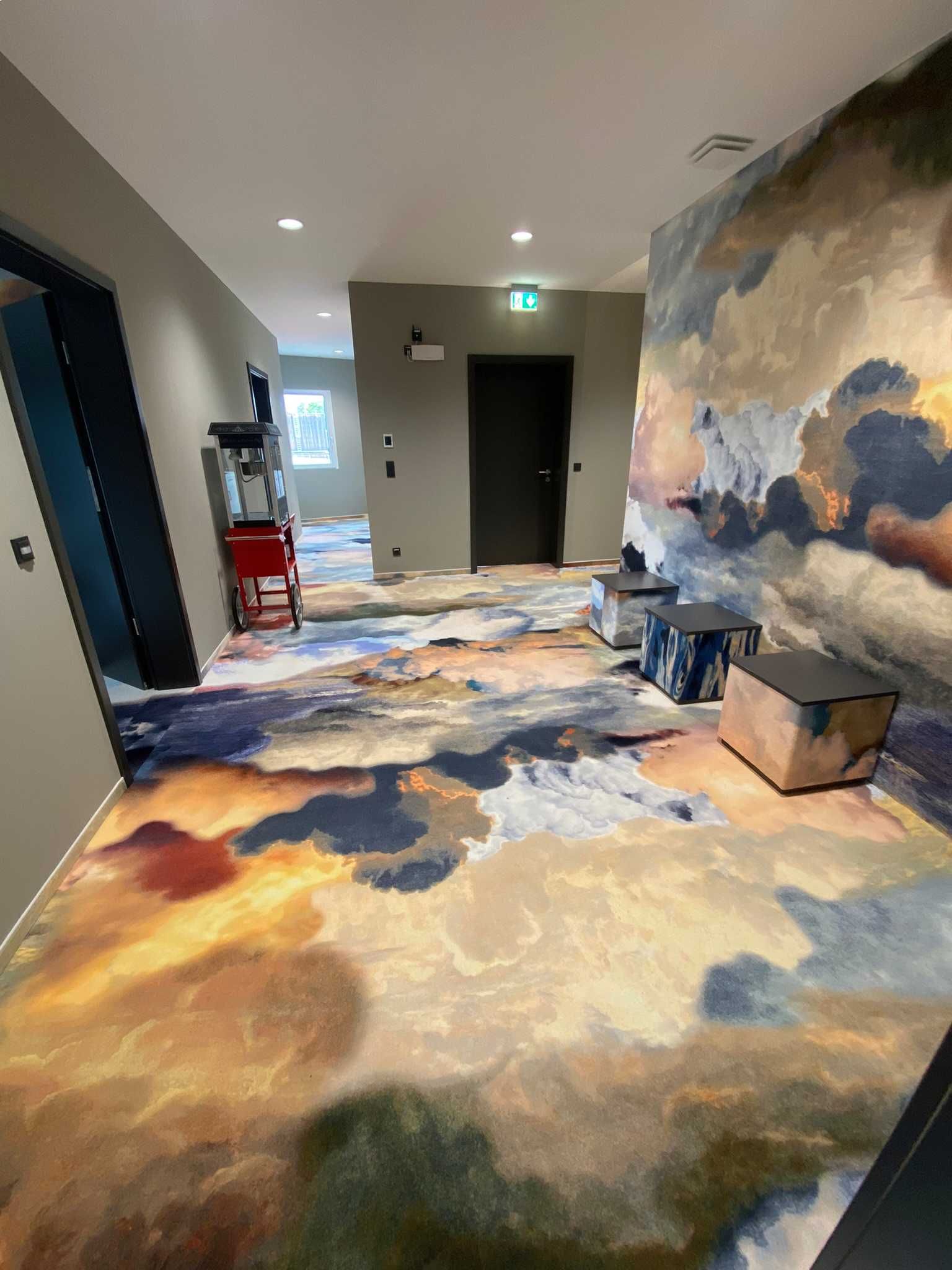 Ein Flur mit einem Gemälde von Wolken an der Wand.