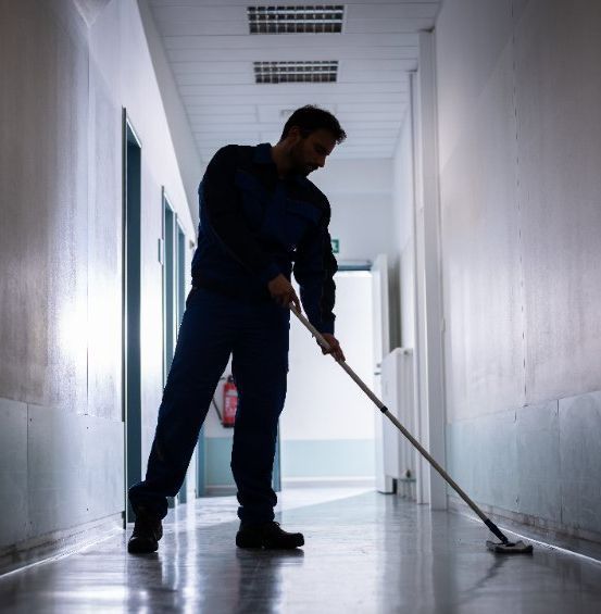 Un hombre con traje y corbata está parado frente a una escalera de madera.