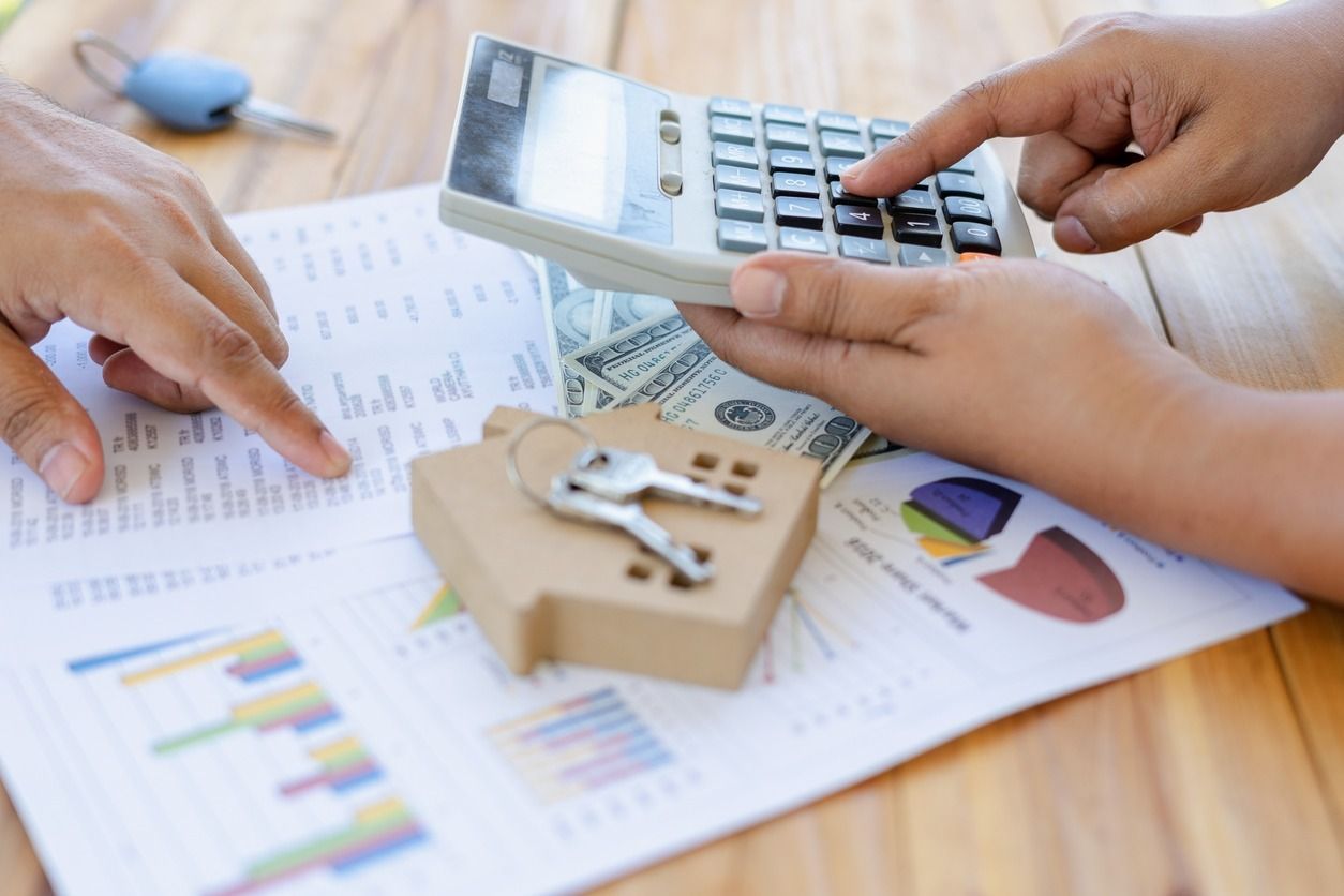 Una persona está usando una calculadora para calcular el costo de una casa.