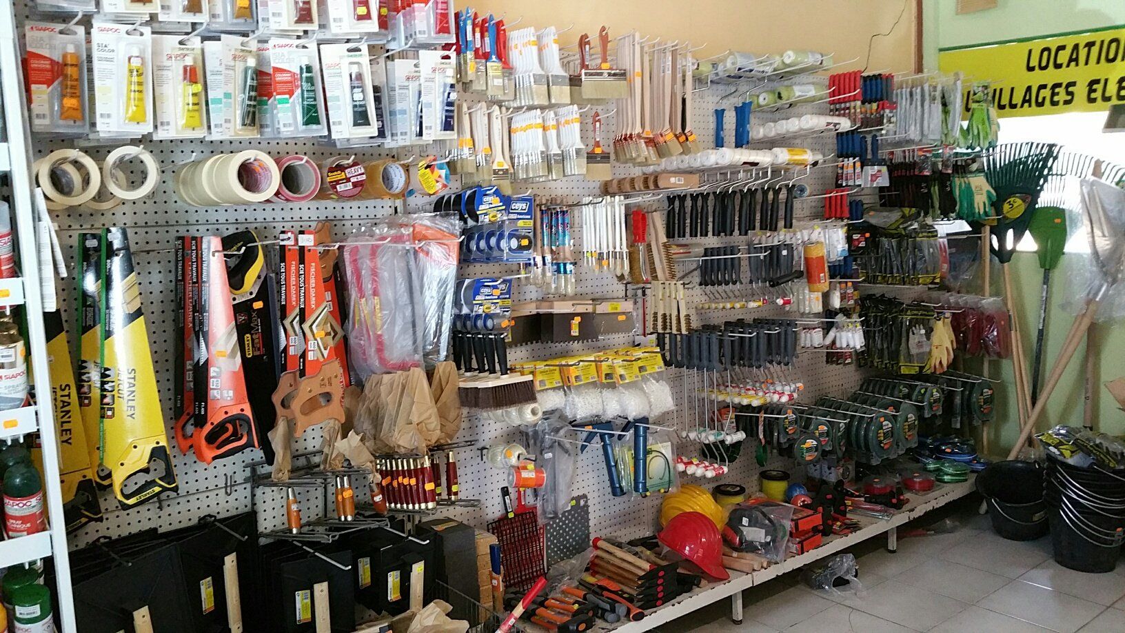 Intérieur de quincaillerie avec outils et fournitures sur des étagères d'exposition.
