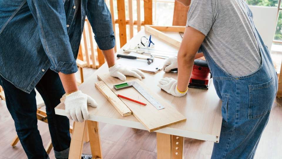 Ein Mann und eine Frau arbeiten an einem Holztisch.