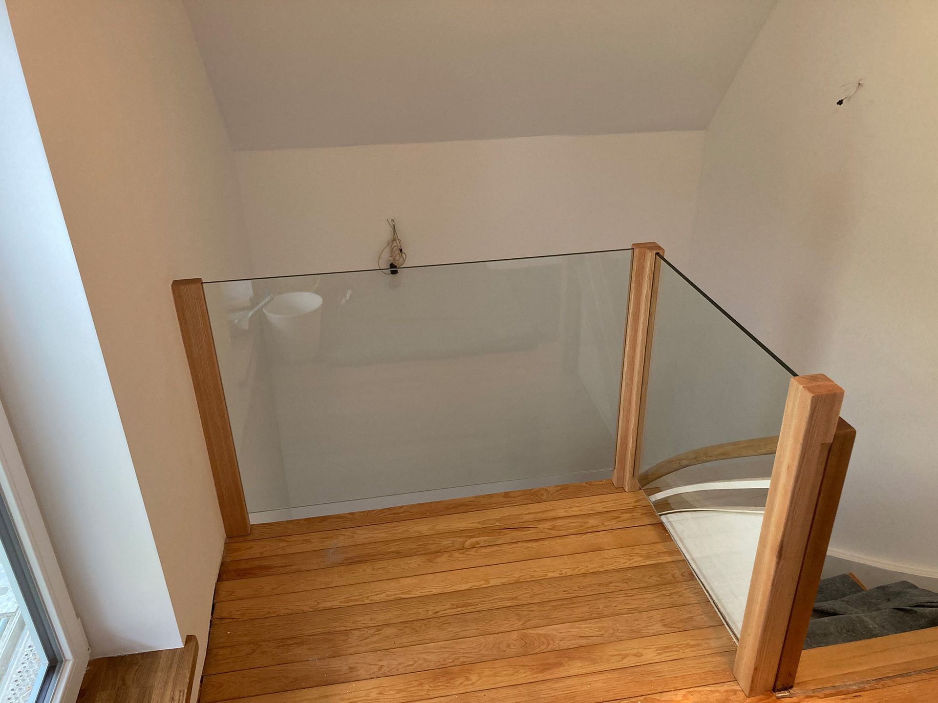 Eine Holztreppe mit einem Glasgeländer in einem Haus.