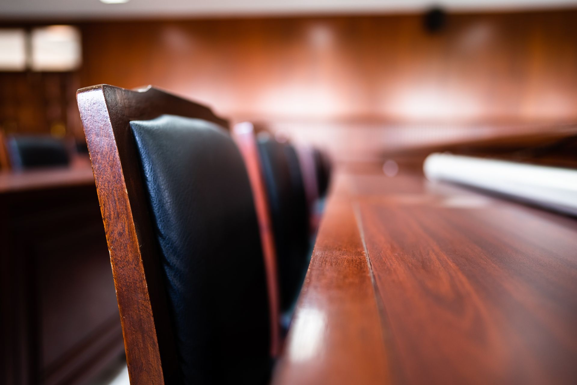 Table de conférence en bois vide avec des chaises noires dans une salle de réunion floue