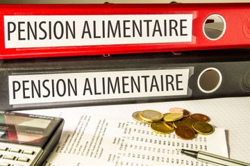 Dossiers de pension alimentaire avec des papiers et des pièces de monnaie sur un bureau