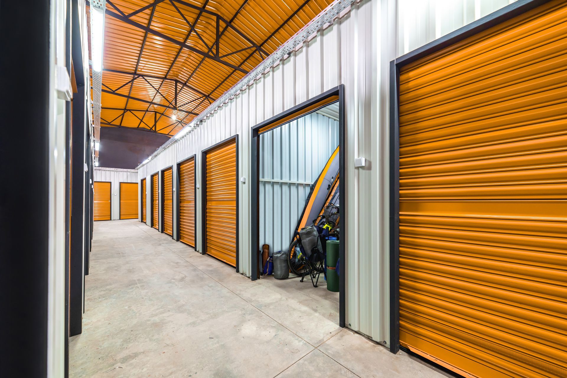 Couloir d'accès à un box de stockage intérieur avec des portes sectionnelles.