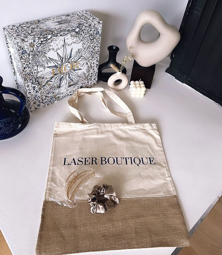 Eine weiße Einkaufstasche mit der Aufschrift „Laser Boutique“
