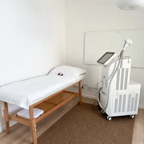 Ein Zimmer mit einem Bett und einer Maschine auf dem Boden
