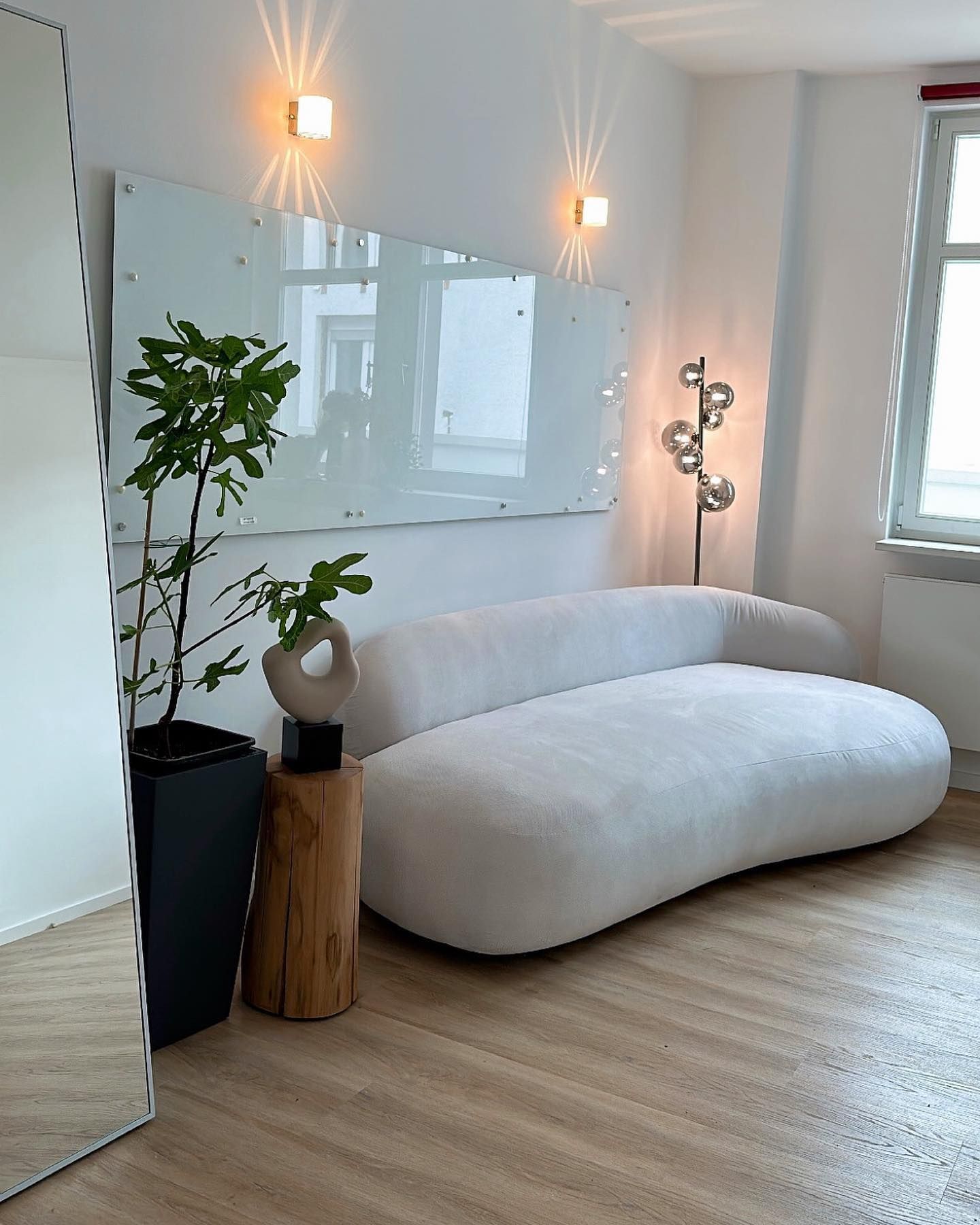 ein Wohnzimmer mit einer weißen Couch und einem Spiegel