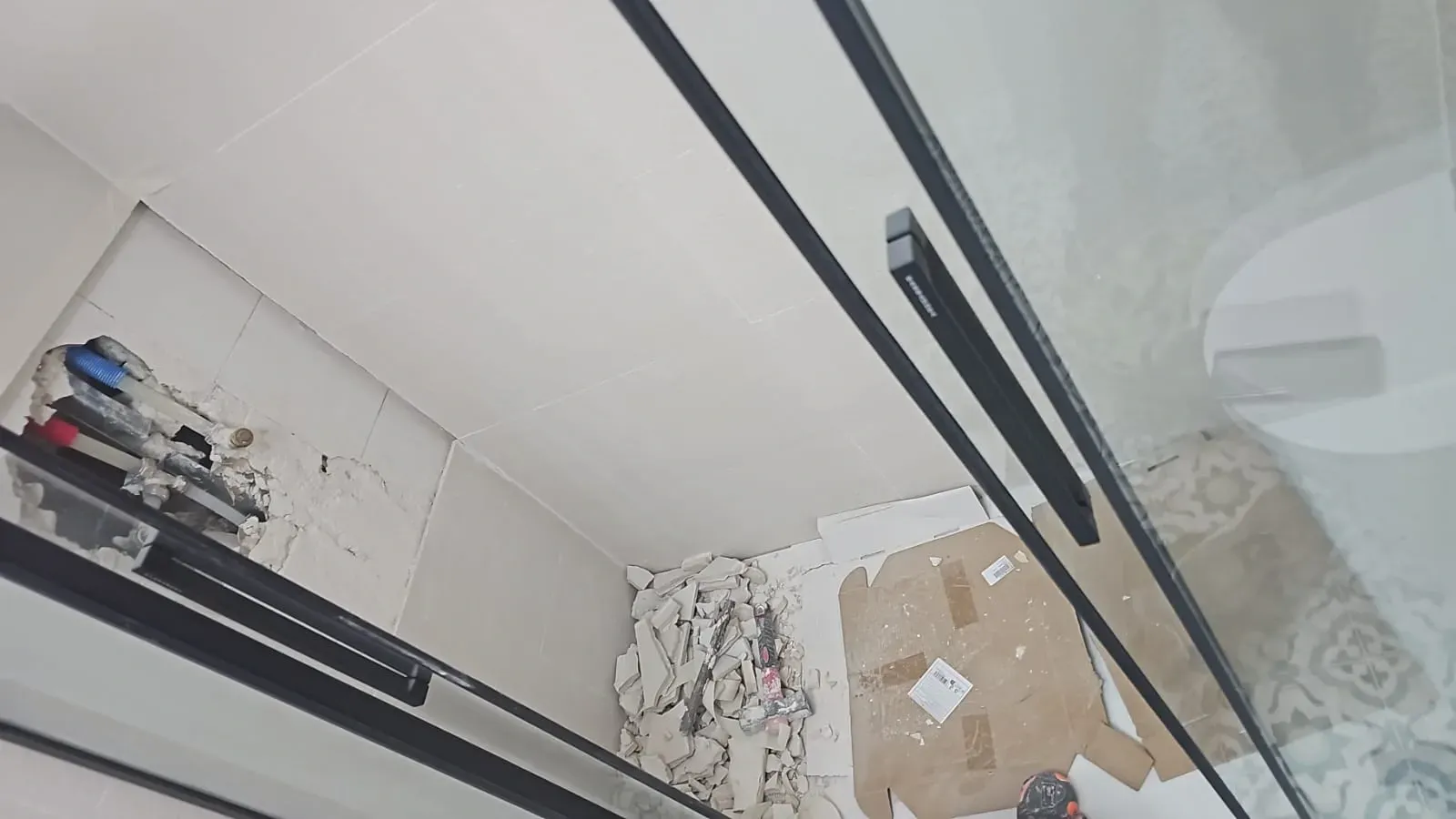 Vista a través de una puerta de cristal de la esquina de una habitación con estantes