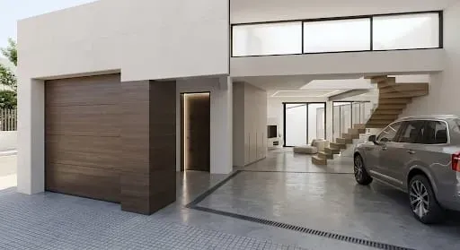 Garaje de casa moderna con puerta de madera abierta, SUV estacionado y escalera visible en el luminoso interior.
