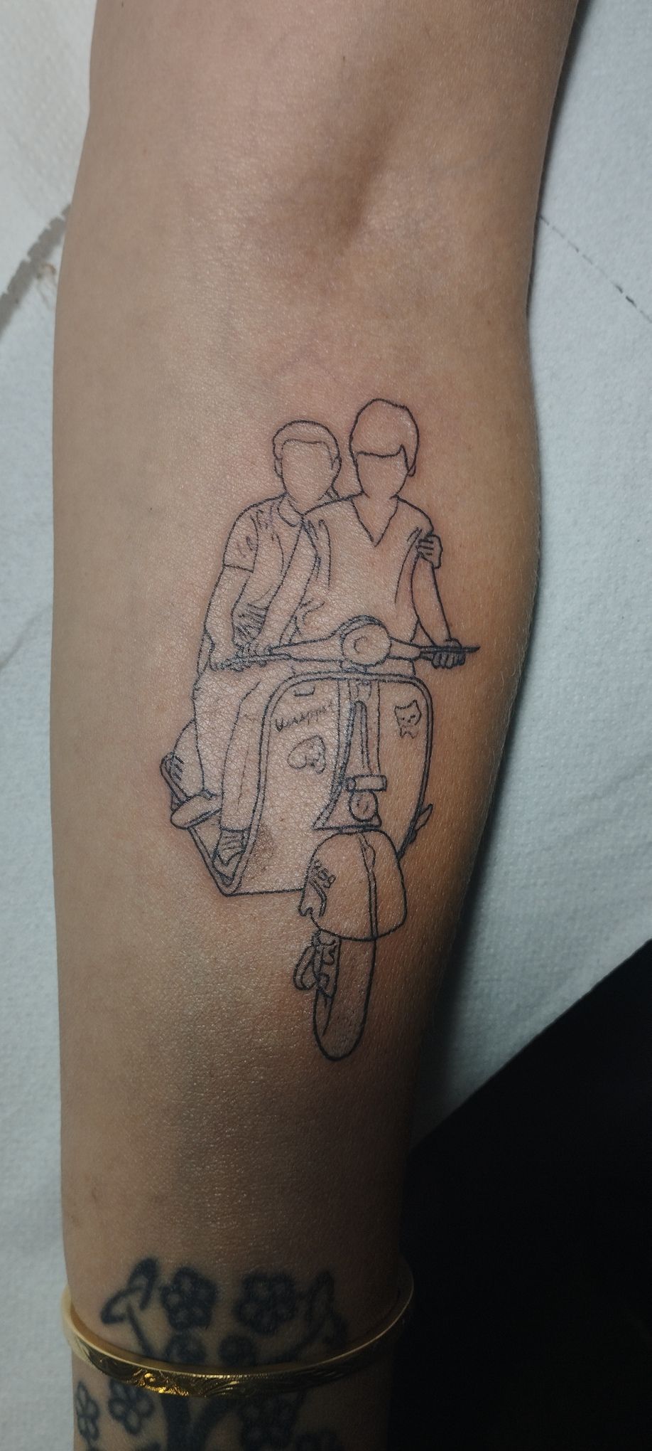 Tatuaje de dos personas conduciendo un scooter.