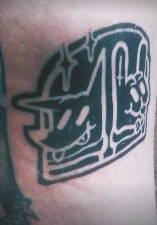 Tatuaje en blanco y negro de un perro con gafas de sol junto a un conejo con símbolos de la paz.