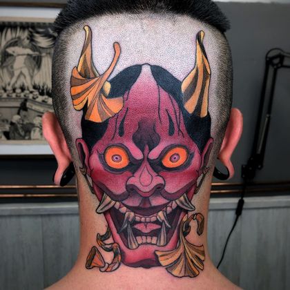 Mujer con intrincados tatuajes florales en los brazos, apoyando la barbilla en la mano.