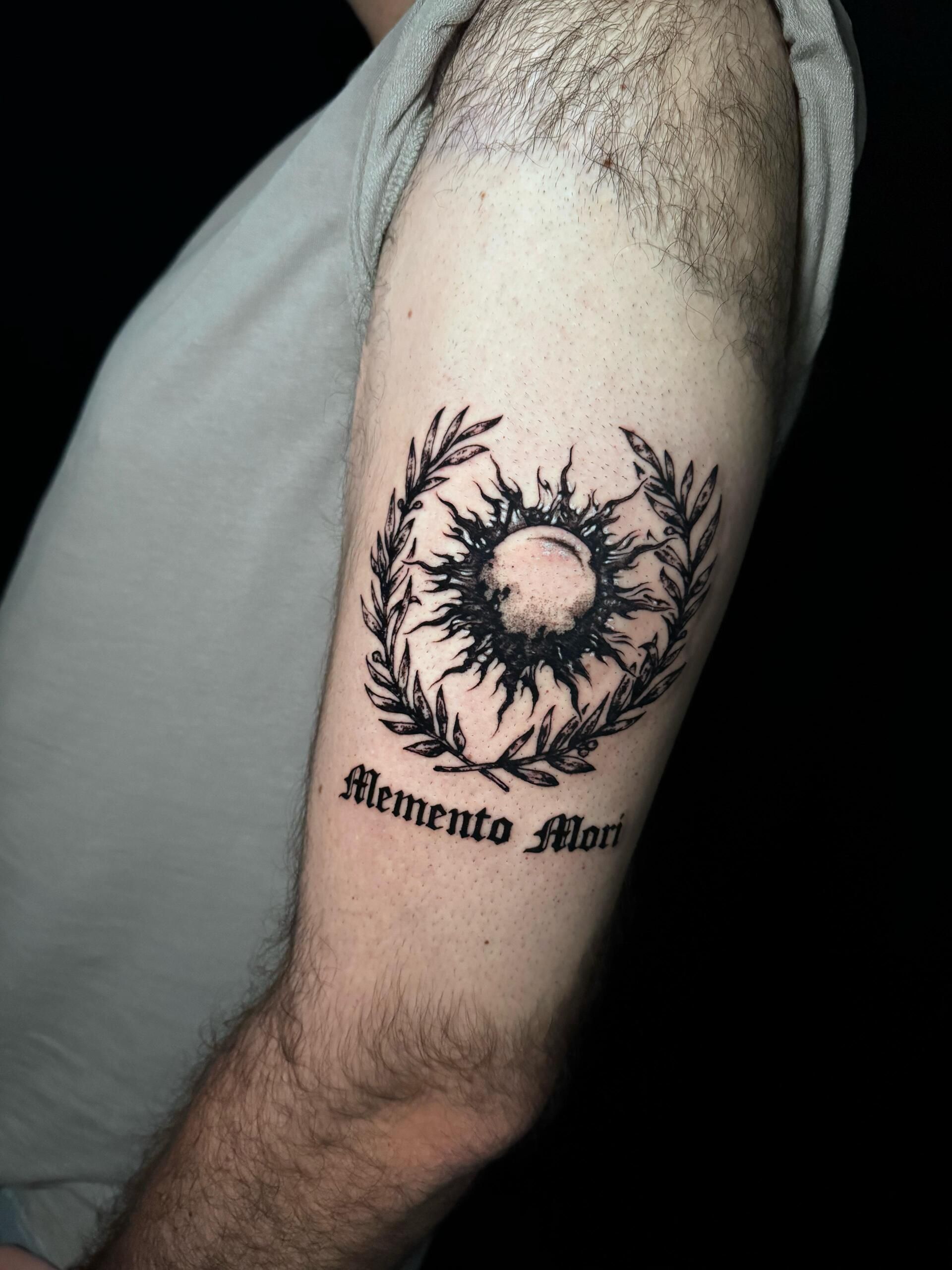 Tatuaje en el brazo: sol con corona de olivo y 