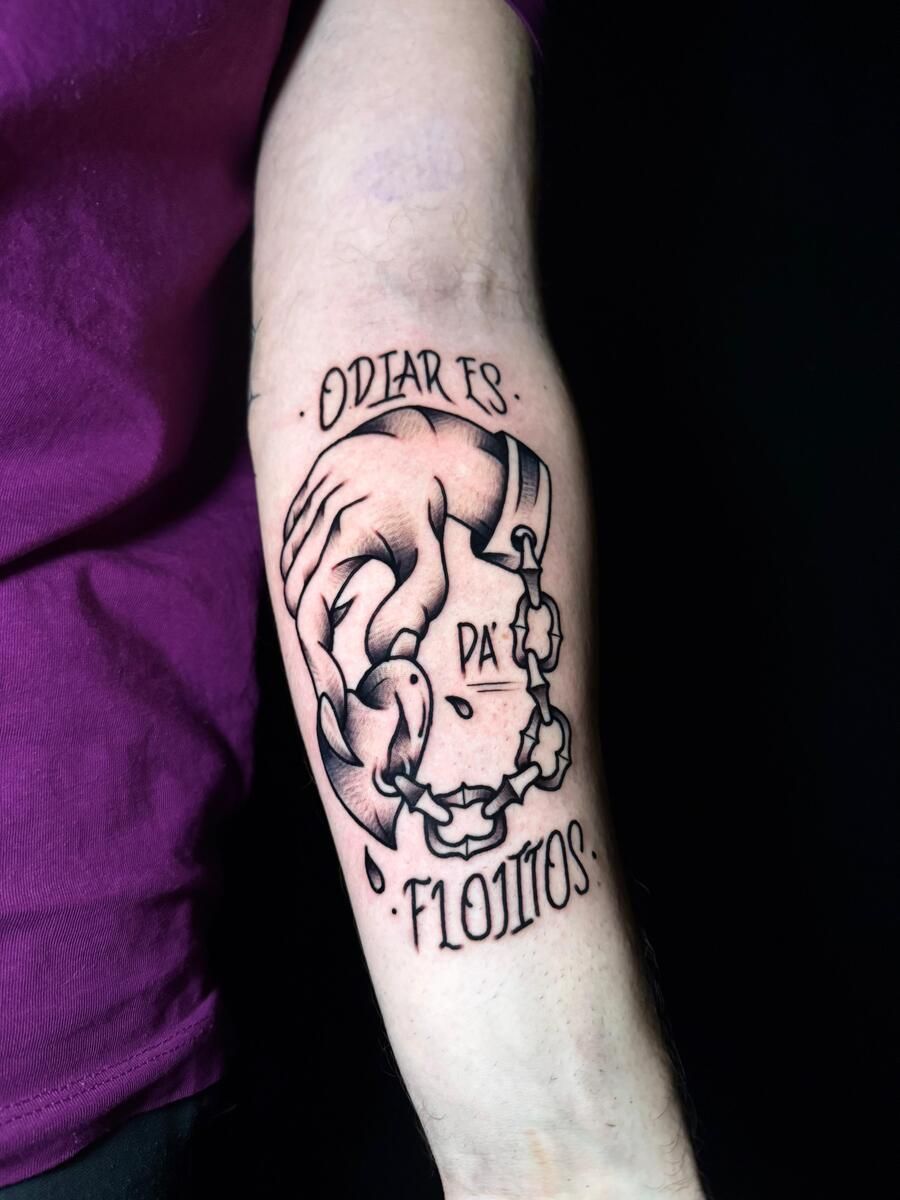 Tatuaje de una mano rompiendo cadenas con el texto: 