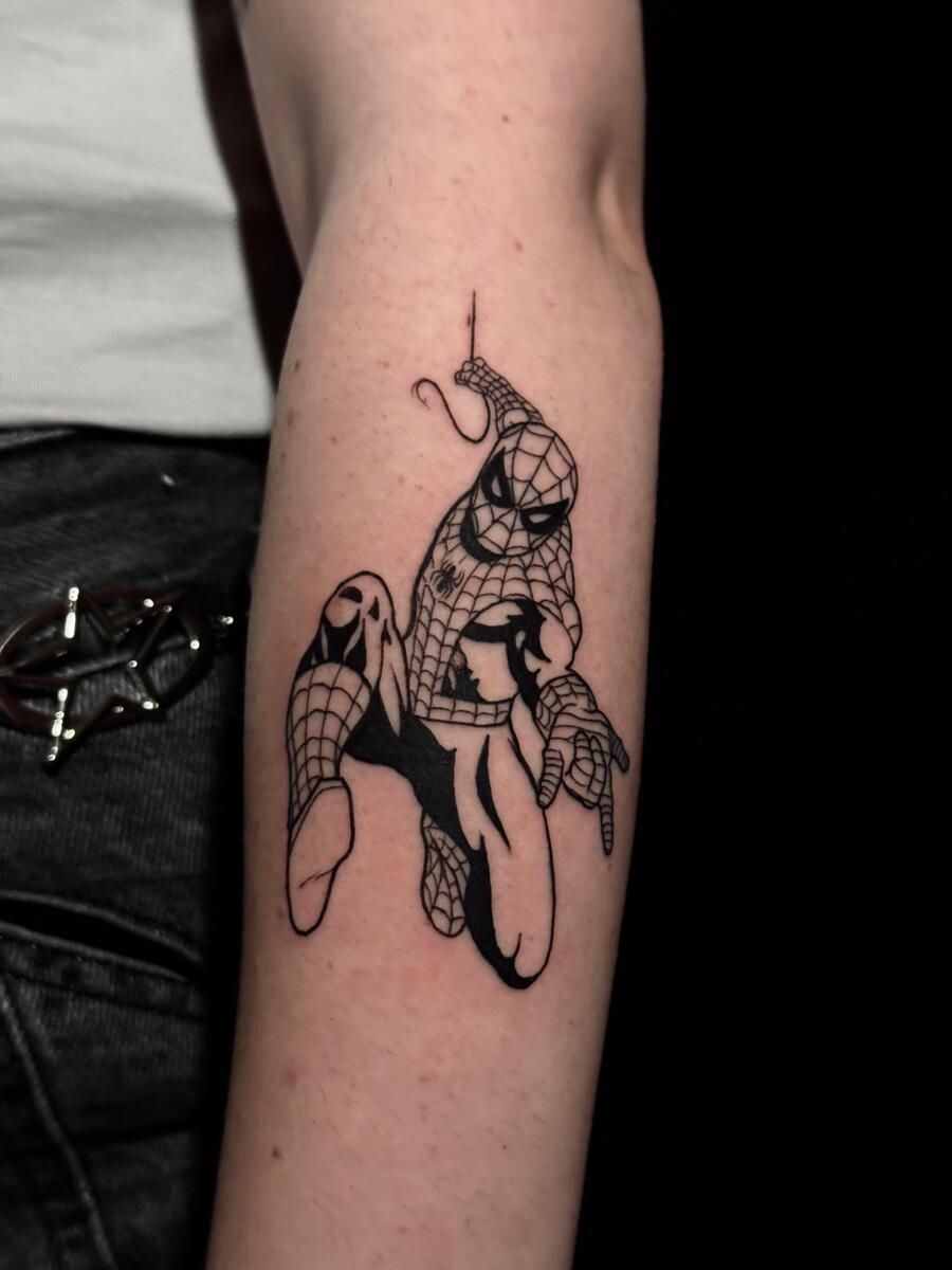 Tatuaje de Spider-Man en un brazo, diseño estilo comic en blanco y negro, colgando de una red.