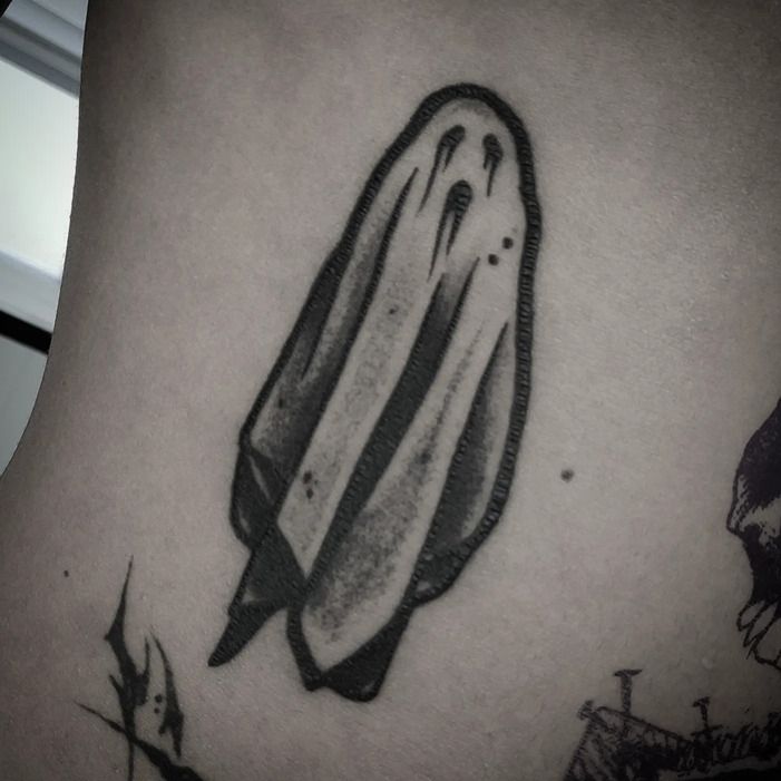 Tatuaje de fantasma en blanco y negro sobre la piel.