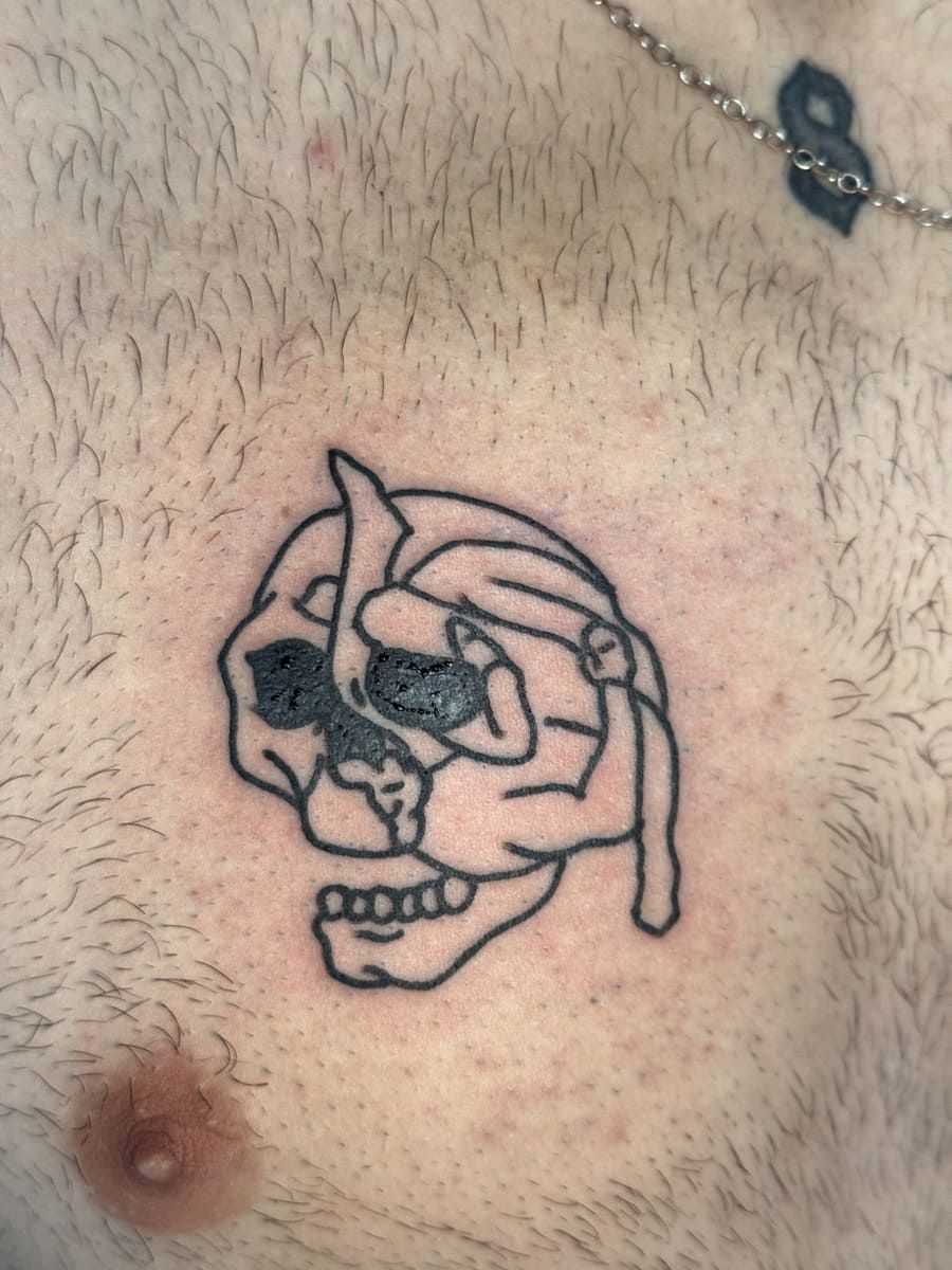 Tatuaje de calavera de contorno negro en el pecho de una persona.