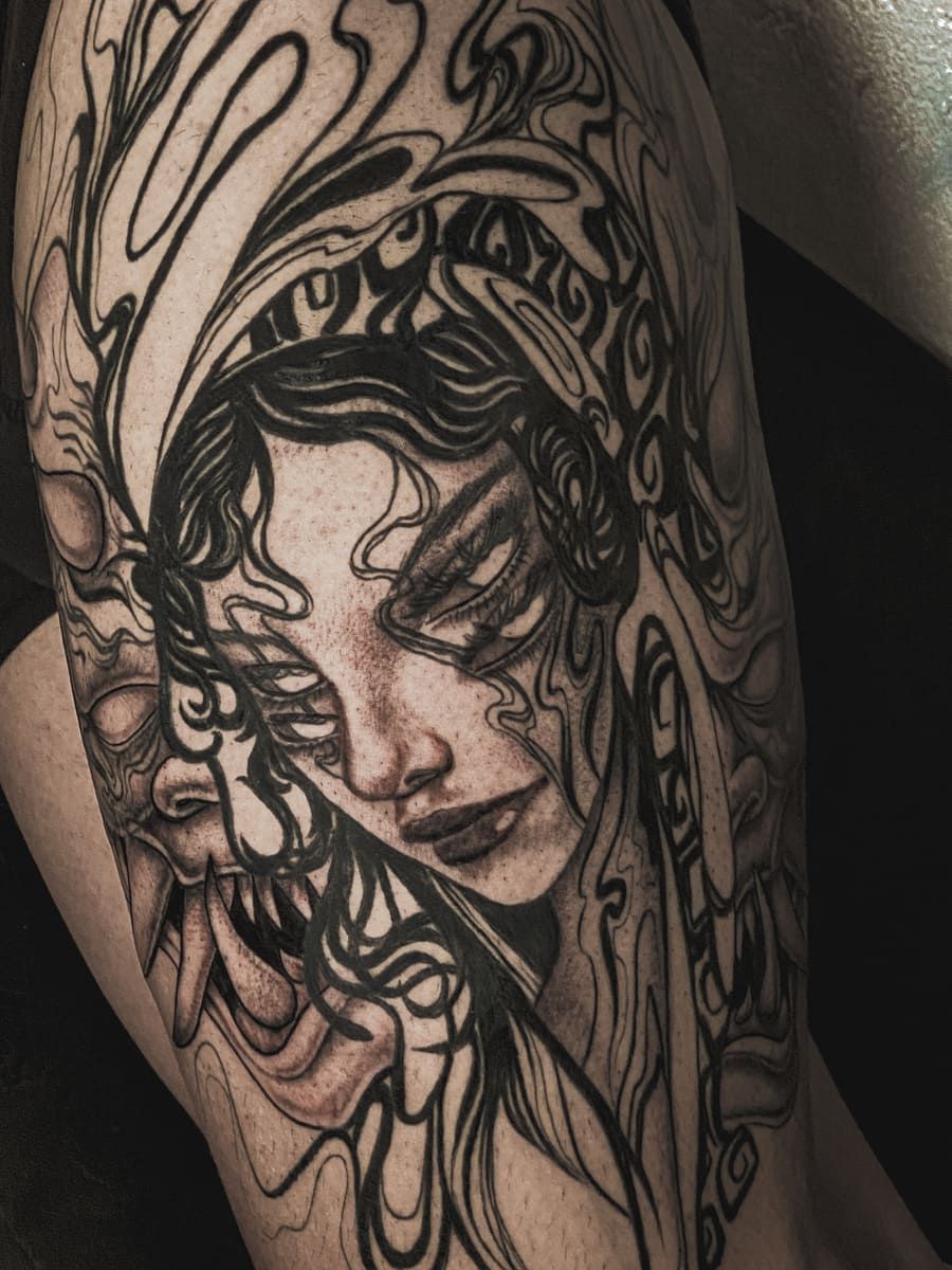 Tatuaje de tinta negra: mujer con ojos cerrados, sombreado detallado, líneas abstractas, cara de monstruo.
