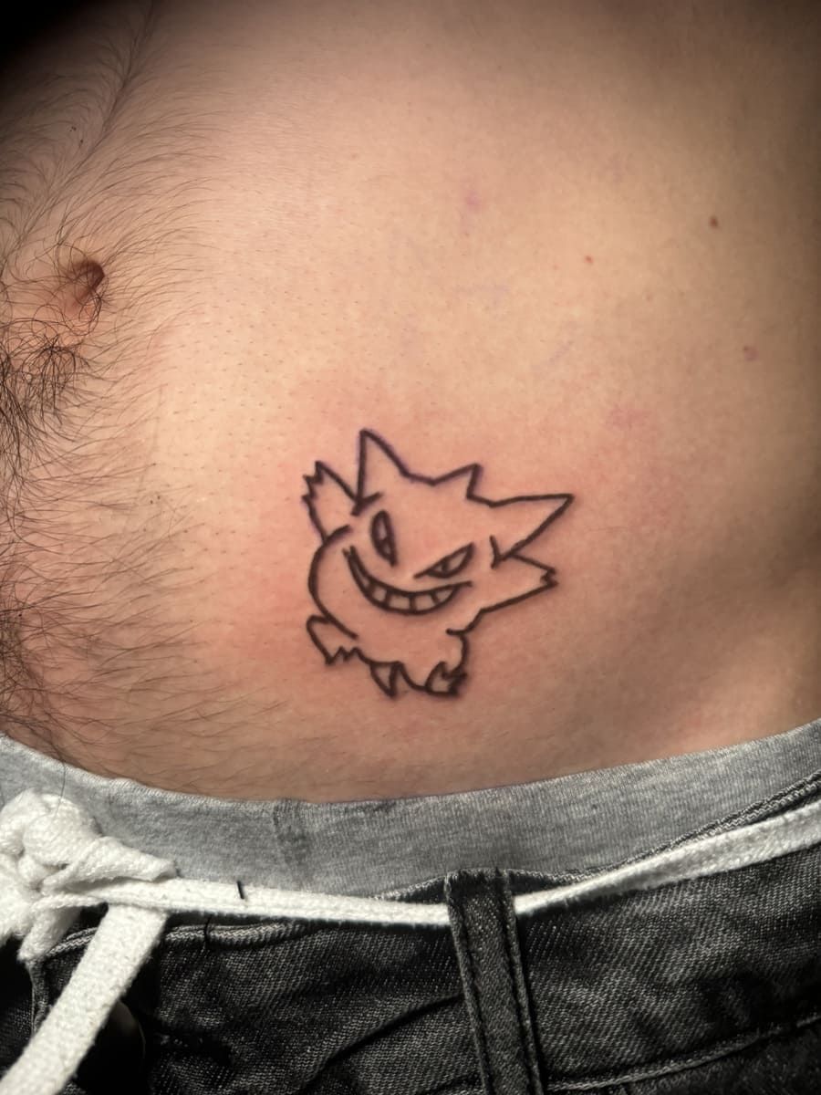 Tatuaje de contorno negro de Gengar en el abdomen de una persona, encima de la cintura.