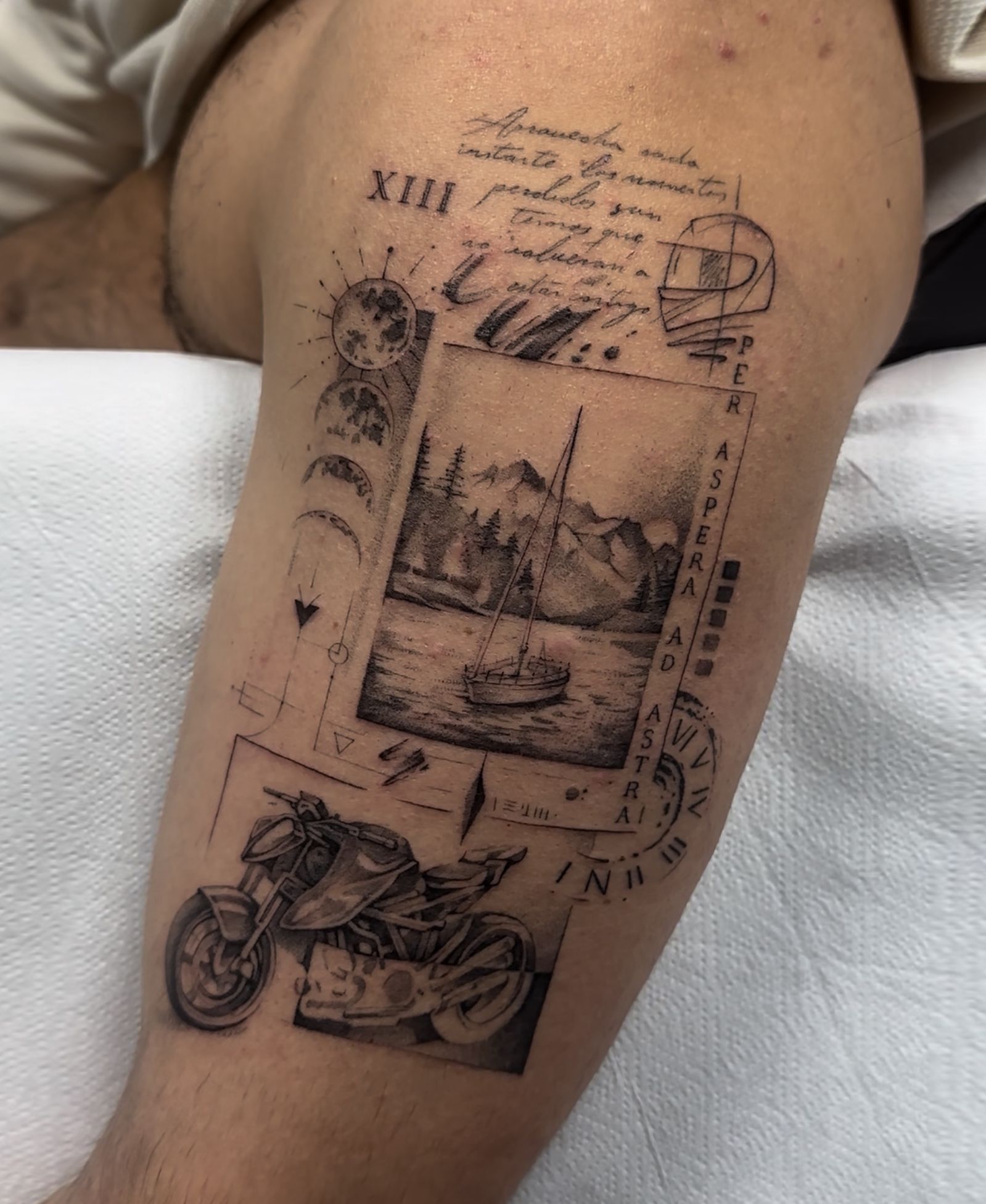 Tatuaje en el brazo que representa una motocicleta, un paisaje marino, un sol, una escritura y un casco dentro de un marco rectangular.