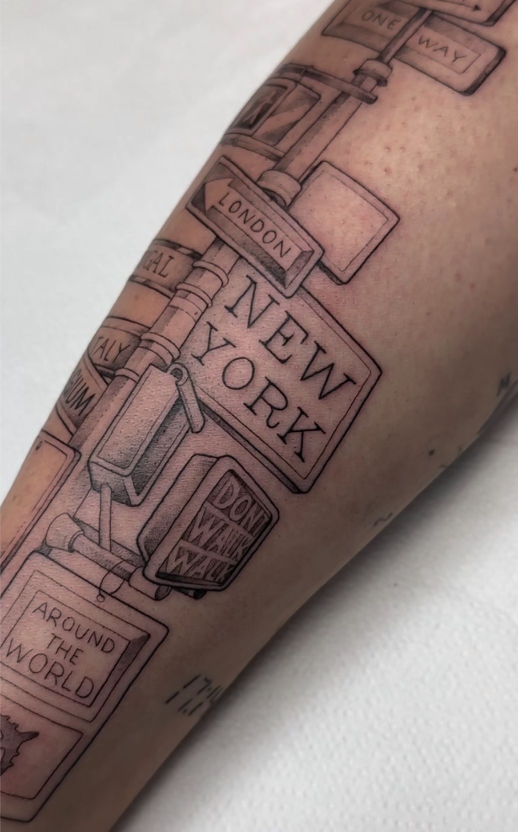 Tatuaje de un cartel direccional con señales que apuntan a 