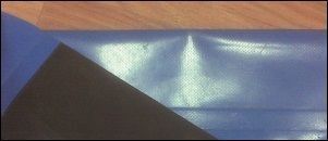 Un trozo de papel azul y negro está sobre una mesa de madera.