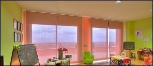 Una habitación con muchas ventanas y juguetes dentro.