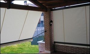 Un toldo blanco cuelga sobre una pared de ladrillos.