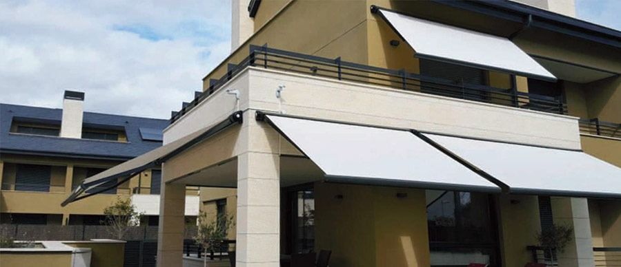 Una casa amarilla con un toldo blanco en el balcón.