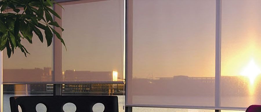 Una puesta de sol se refleja en las persianas de una ventana.