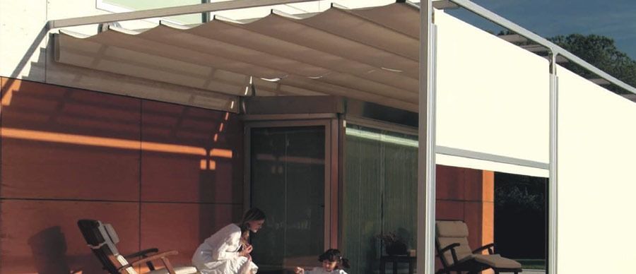 Una pareja está sentada bajo un dosel en un patio.