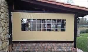 Una pared de ladrillos con una ventana y una persiana.