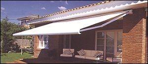 Una casa de ladrillo con un toldo blanco sobre el porche.
