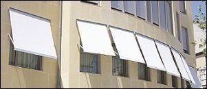 Un edificio con muchas ventanas y persianas blancas.
