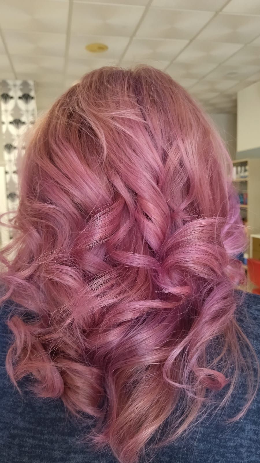 Mujer con cabello ondulado y rosa.