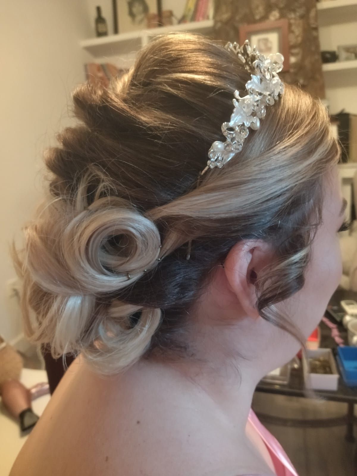 Mujer con peinado recogido rubio y castaño, adornado con un tocado floral.