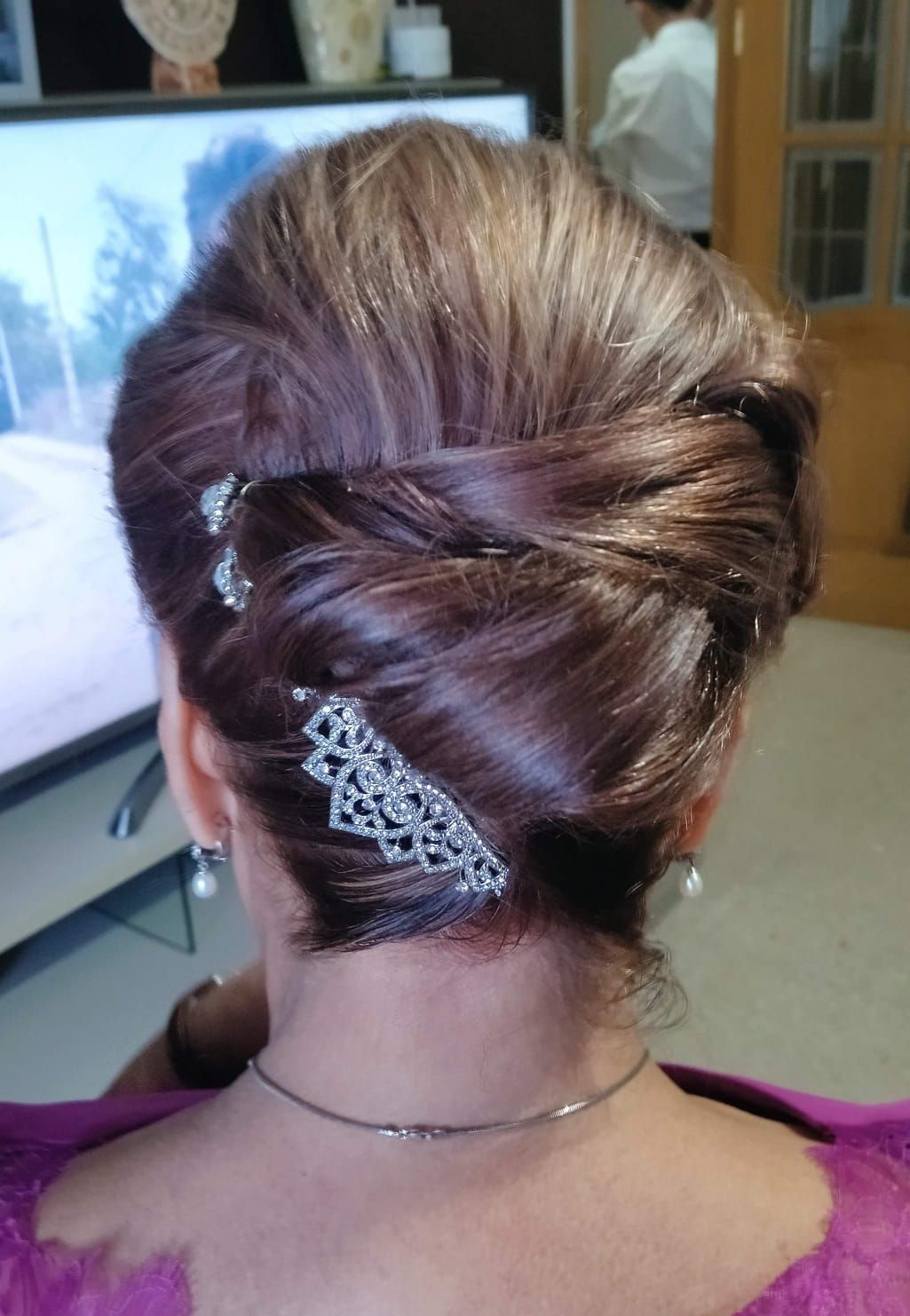 Peinado recogido castaño con horquillas decorativas.