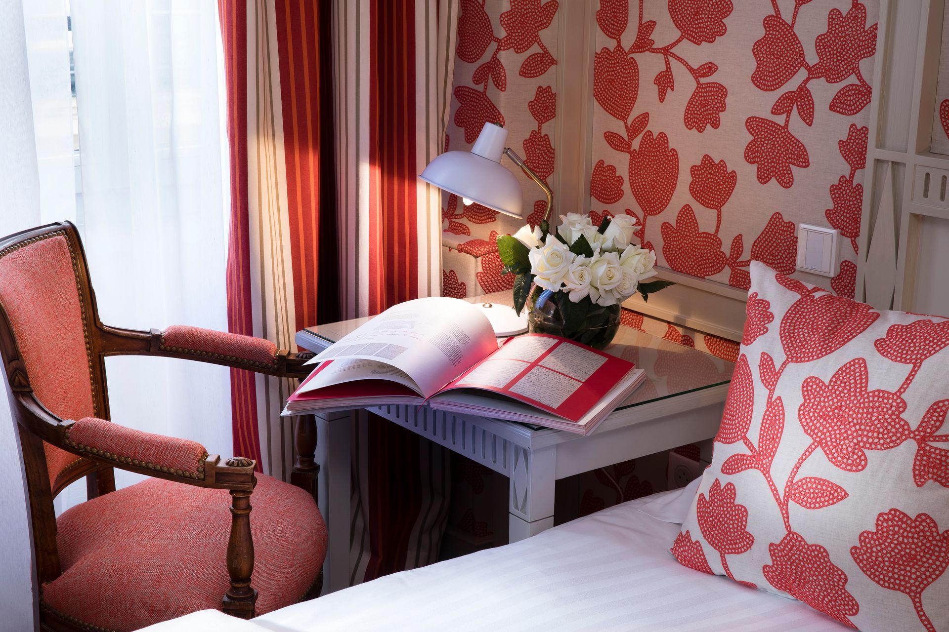 Intérieur de chambre avec bureau, livres, papier peint, fleuri, chaise et fleurs.