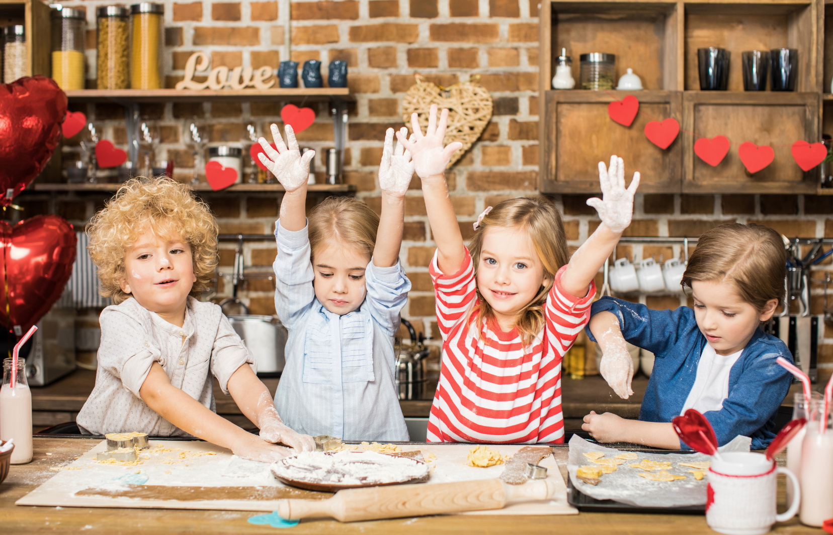 Quatre enfants en train de cuisiner sur un plan de travail en bois