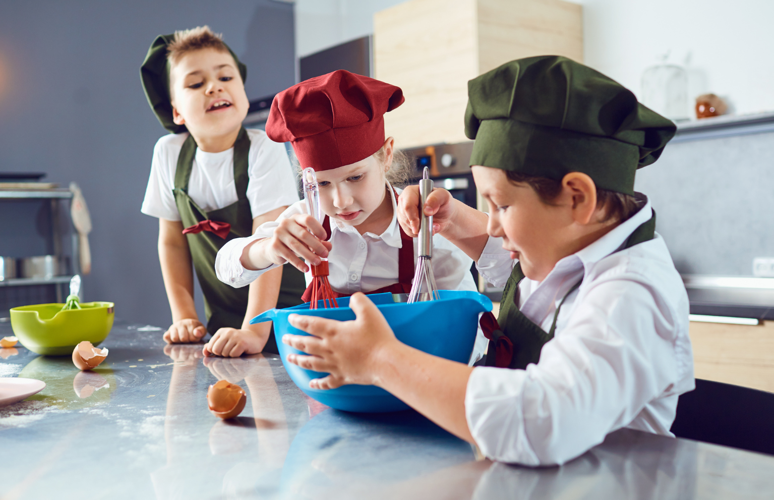 Enfants en train de battre des œufs au fouet dans un saladier bleu