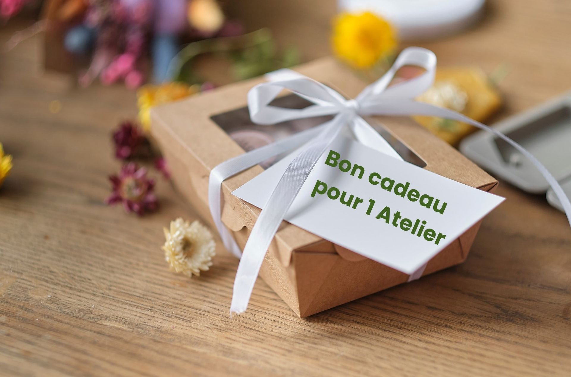 Paquet cadeau posé sur une table en bois avec la mention bon cadeau pour un atelier