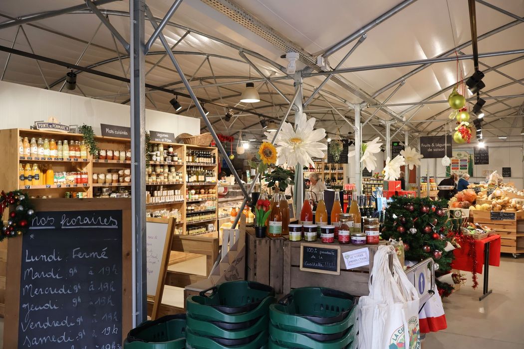 Entrée du magasin fermier, ardoise avec horaires d'ouvertures, quelques produits visibles