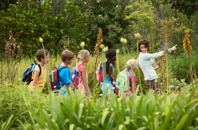 Enfants et accompagnant dans un champ fleuri