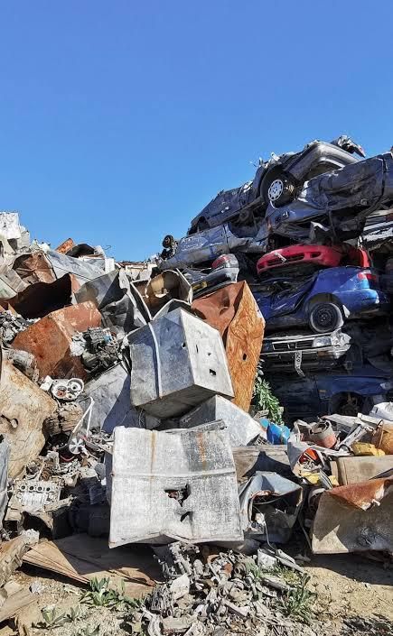 Un tas d'appareils électroménagers mis au rebut et de ferraille entassés dans une décharge à ciel ouvert sous un ciel bleu